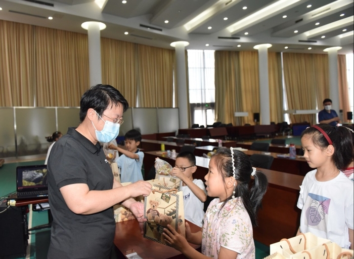 图为山东省药监局局长于涛（左一）为看护班的孩子们送上小礼物。