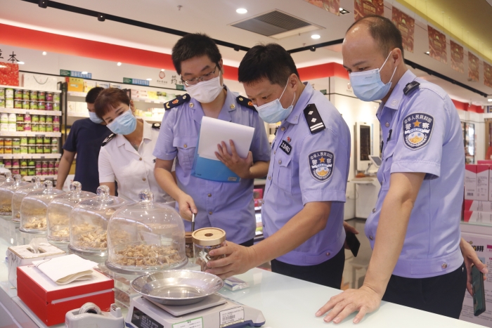 图为检查组在一家药店检查药品进货渠道、储存、陈列和销售等重点环节。