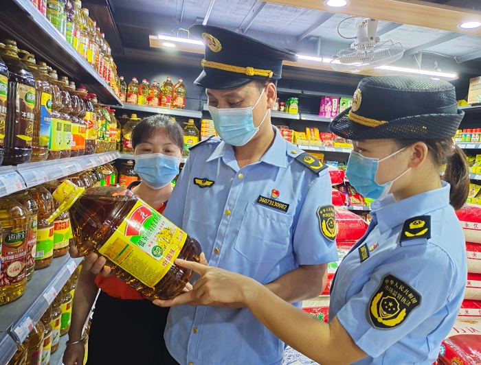 图为该局执法人员在一家超市检查食用油。