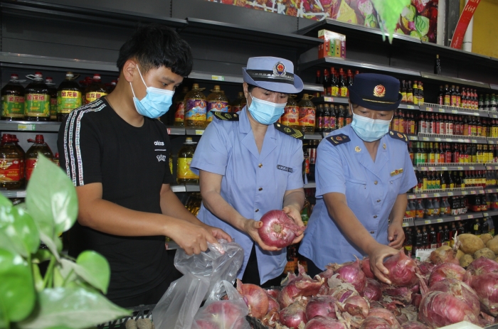 图为执法人员和检测机构工作人员抽取蔬菜样品送检。