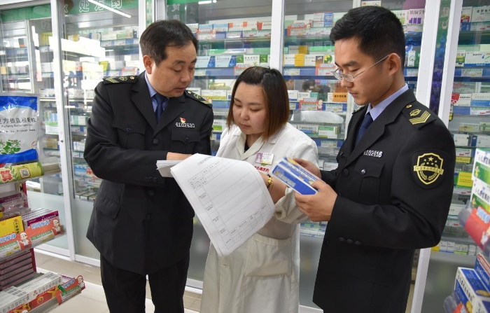 图为该局执法人员正在一家药品零售企业检查质量管理体系文件是否执行到位。