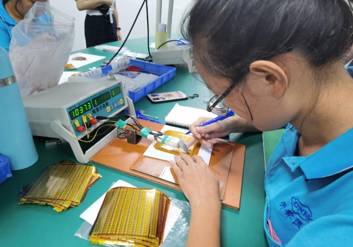 在忻城县医疗器械产业园，开蒙医疗员工在调试人体成分分析仪传感器芯片的阻桥电路的阻值。