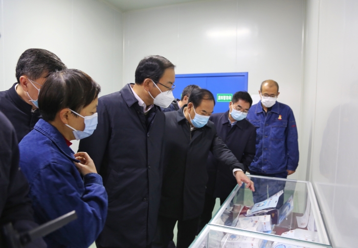 图为甘肃省副省长张世珍在兰州宝石花医疗器械有限公司查看医用口罩等防疫物资生产、储备情况。