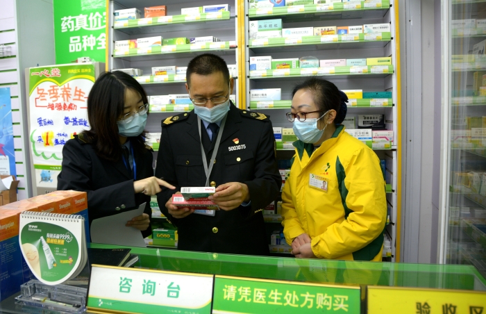 图为执法人员在一家零售药店检查特殊药品销售情况。
