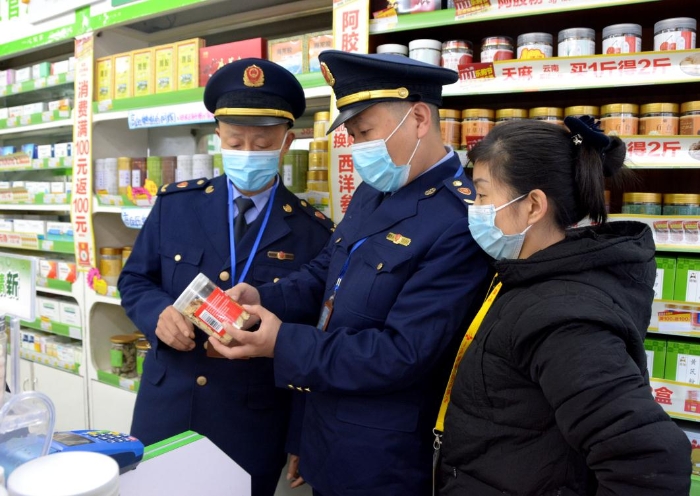 图为该局江北街道市场监管所执法人员在一家药店核查。