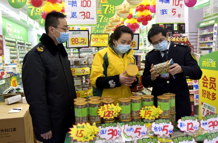 图为1月14日监管人员在一家药店检查。