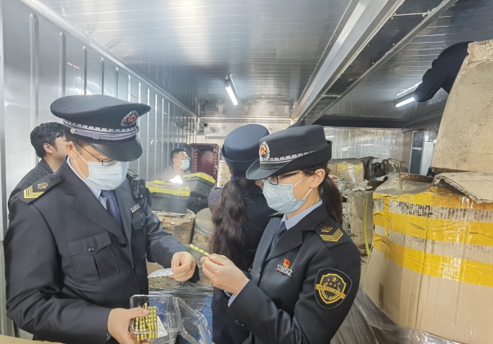 图为青岛市市场监管局执法人员在某仓库查获假劣药品。
