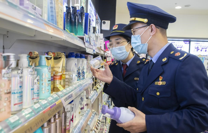 图为执法人员在超市化妆品专柜检查化妆品标签标识情形。