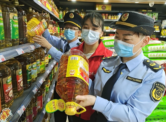 图为执法人员正在一商店检查食品。