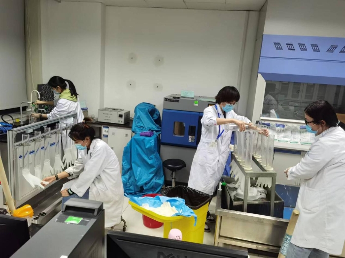 图为山东省医疗器械和药品包装检验研究院应急检验团队检验医用橡胶手套的不透水性。