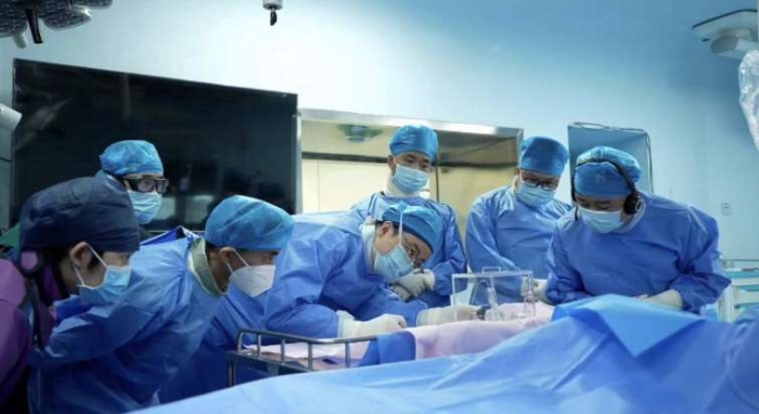 图为向华教授带领湖南省人民医院介入血管外科团队施行手术。