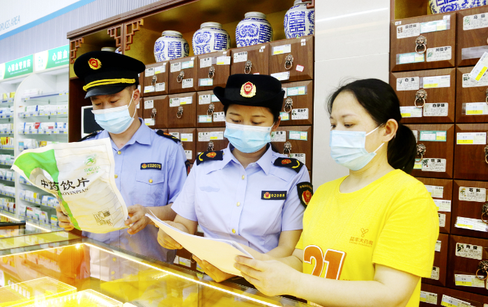 图为6月7日，渝水区市场监管局执法人员在一家零售药店检查中药饮片储存情况。