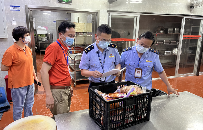 图为连江县市场监管局执法人员在一家考点学校食堂检查食品储存情况。