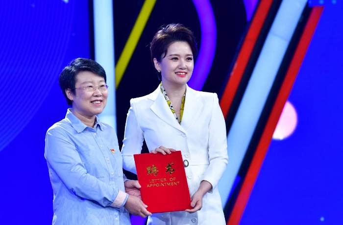 图为于涛（左）为化妆品安全科普公益宣传大使颁发聘书。