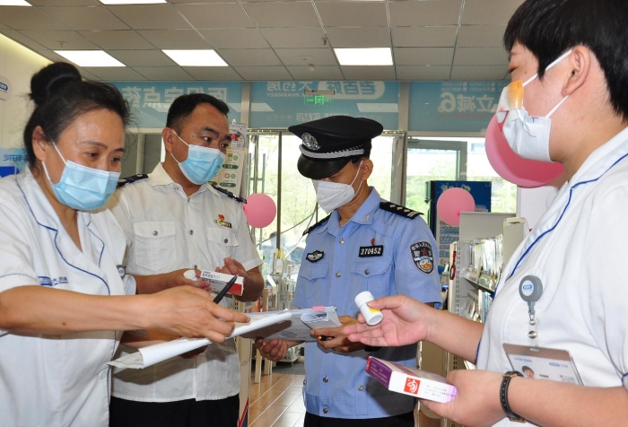 图为检查组现场查看药店进销台账、盘点库存、查验处方等情况。