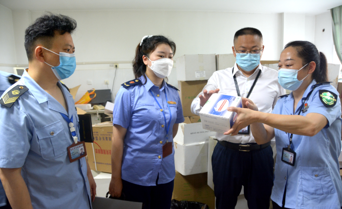 图为涪陵区市场监管局执法人员在一家医院检查新冠病毒检测试剂是否具备合格证明文件。