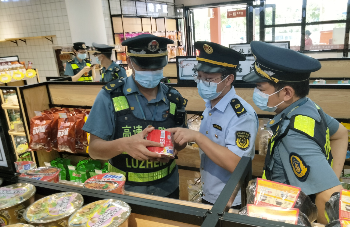 图为6月27日，于都县市场监管局执法人员在于都北服务区一家超市内检查是否存在经营过期食品问题。