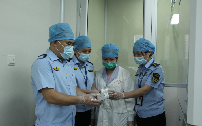 图为钟山县市场监管局执法人员在一家新冠肺炎病毒检测试剂使用单位检查。