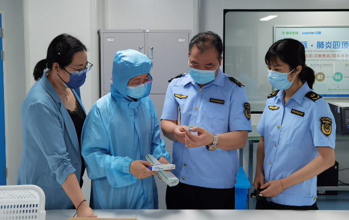 图为山东省药监局执法人员在一家企业包装间对未包装的产品成品进行现场检查。
