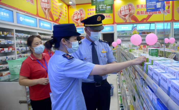 图为涪陵区荔枝街道市场监管所执法人员在一家药店检查药品储存情况。