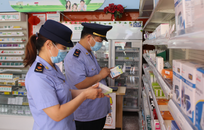 图为8月9日，尉氏县市场监管局执法人员在一家药店检查在售药品标识。