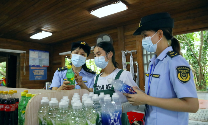 图为南宁市市场监管局青秀山风景区分局执法人员在一家景区食品经营店检查食品安全。