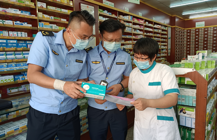 图为该局监管人员对一家药店开展新冠病毒抗原检测试剂质量安全检查。
