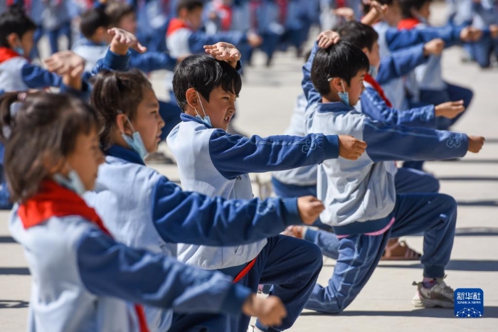在新疆阿克苏地区乌什县依麻木镇国家通用语言小学，学生们在做课间操（2022年6月8日摄）。新华社记者 丁磊 摄