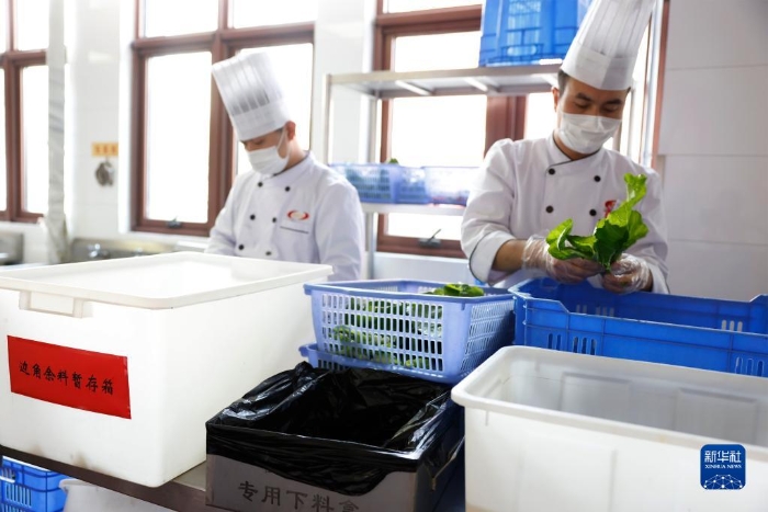 在某中央国家机关食堂，厨师将菜根等边角余料放入暂存箱（2020年10月26日摄）。新华社记者 刘彬 摄