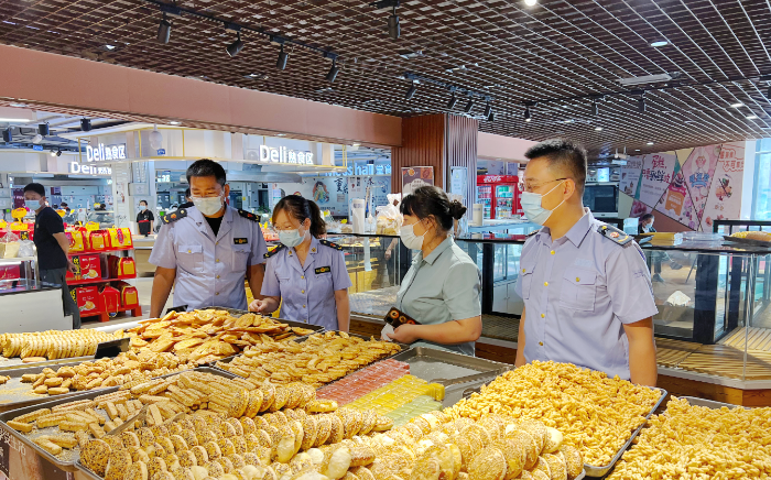 图为该局执法人员在一家超市检查食品质量安全。