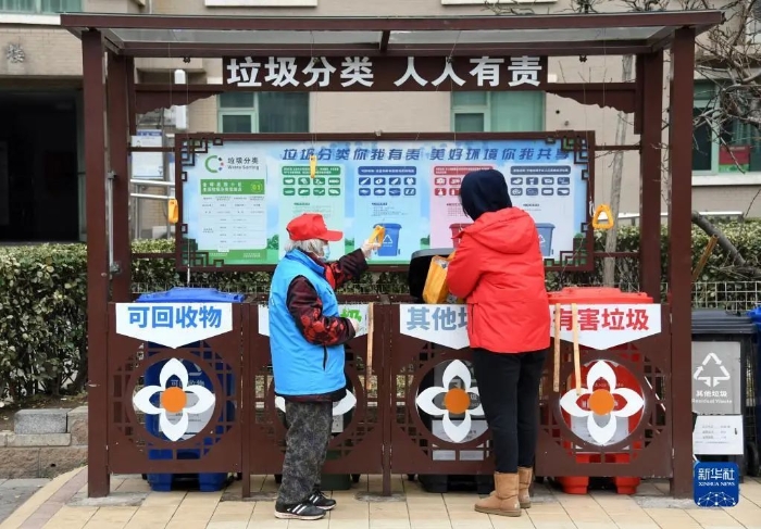 在北京市海淀区北太平庄街道金晖远洋社区，志愿者（左）指导社区居民垃圾分类（2021年3月5日摄）。新华社记者 任超 摄