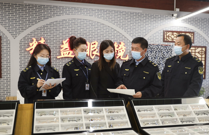 图为该局执法人员在一家眼镜店检查彩色隐形眼镜进货记录。