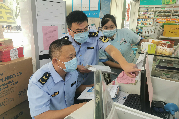 图为该局执法人员在景区一家药店检查“四类药品”购药信息登记。