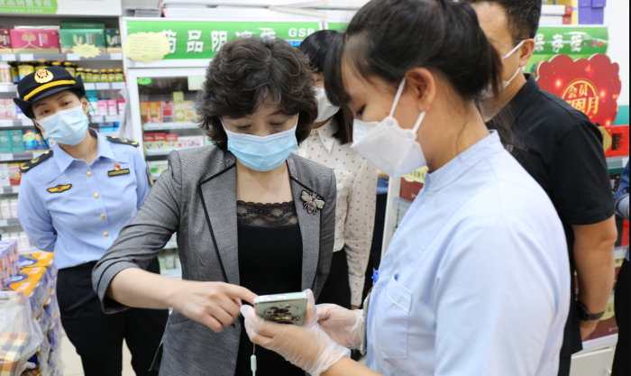 图为北京市药监局局长吴彬带队检查药店场景。