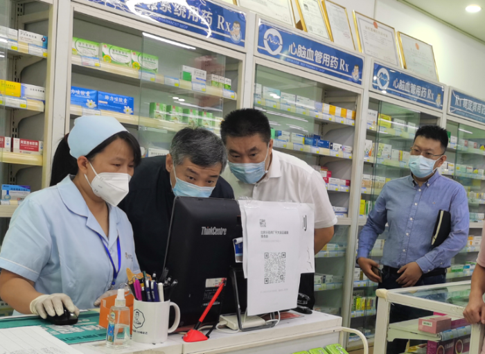图为北京市药监局党组书记于海波带队检查药店场景。