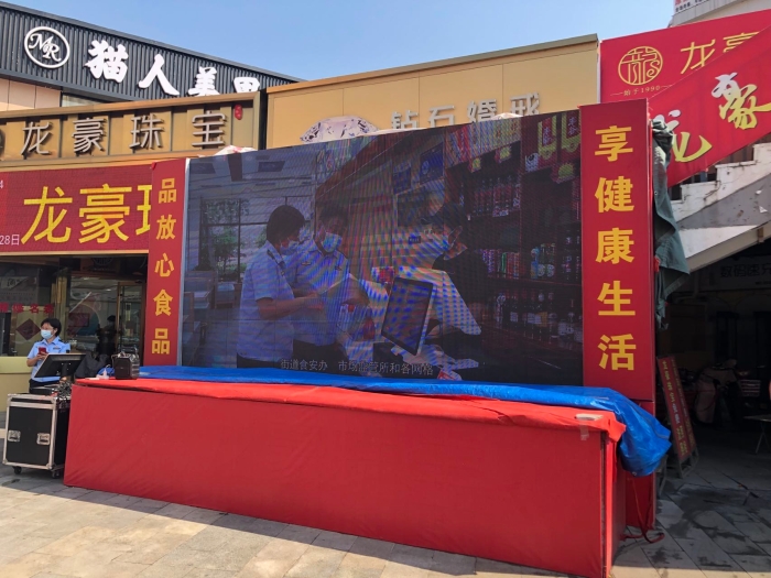 图为刘南宅餐饮聚集区中央大屏幕播放食品安全检查情况。