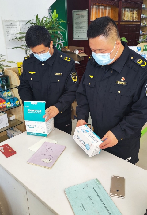 图为武汉市蔡甸区市场监管局执法人员在药店检查医用口罩。（吕海蓉摄）
