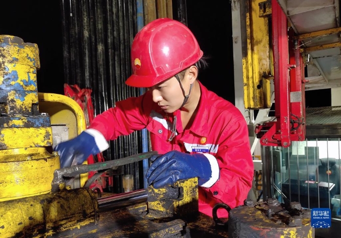 10月17日，黑龙江大庆油田1205钻井队青年员工葛依凡在作业中。新华社发（段永坚 摄）