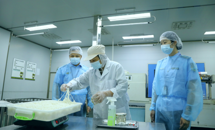图为该局工作人员在广西三品王米粉生产基地对鲜湿米粉开展出厂检验取样。