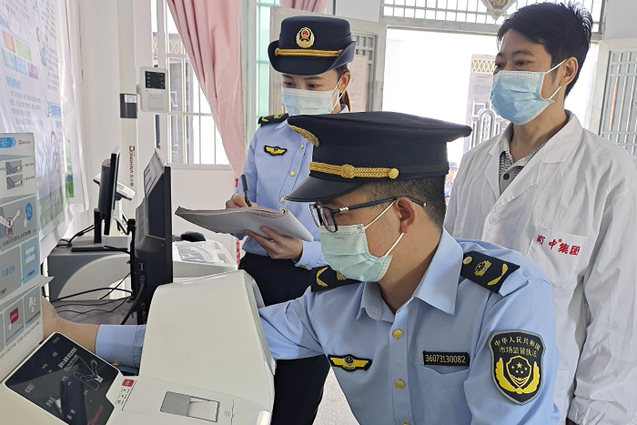 图为11月21日，该局执法人员在一家乡镇村卫生服务中心检查血压计。