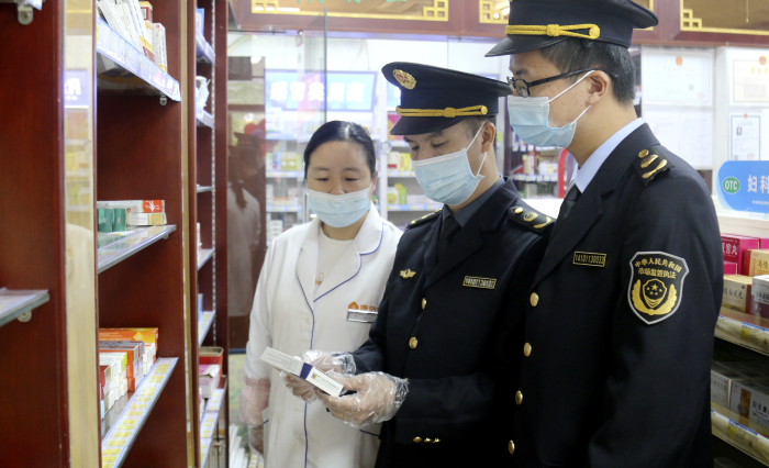 图为该局执法人员在一家药店检查疫情防控药品。