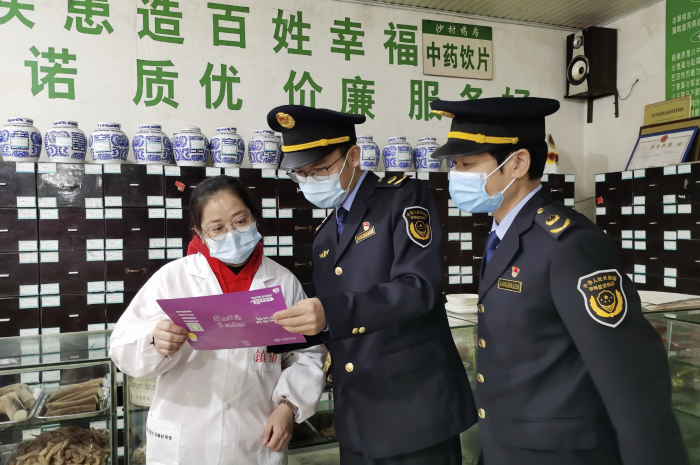 图为11月28日，泰和县市场监管局沙村分局工作人员在一家药店开展宣传活动。