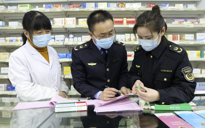 图为11月25日，枞阳县市场监管局执法人员在一家零售药店检查药品销售情况。