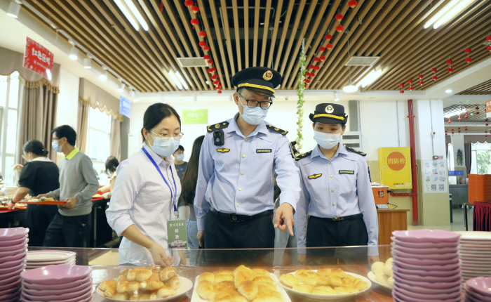 图为南宁市市场监管部门工作人员对大学自助餐厅菜品进行现场检查。
