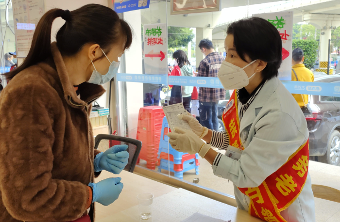 图为执业药师对前来领取拆零袋装布洛芬的群众仔细说明用药注意事项。