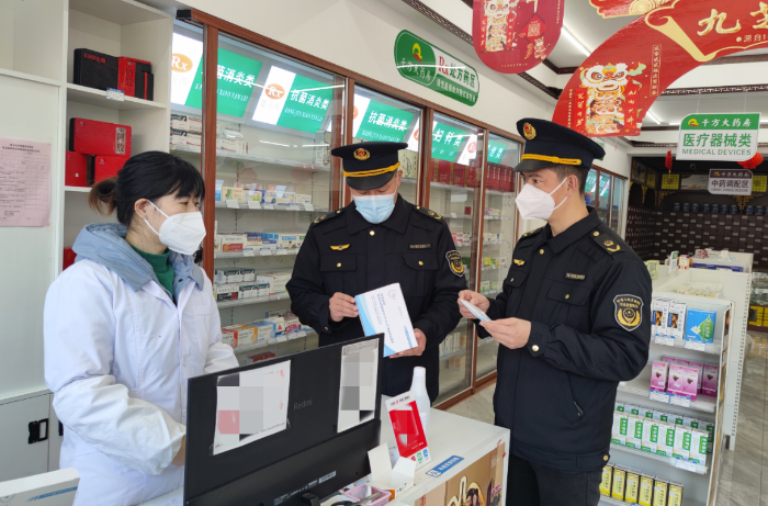 图为该局执法人员在一家零售药店检查新冠病毒抗原检测试剂质量。