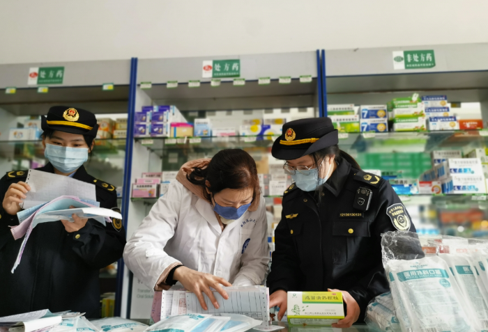 图为1月11日，该局执法人员在一家药店核查防疫药品进货渠道。