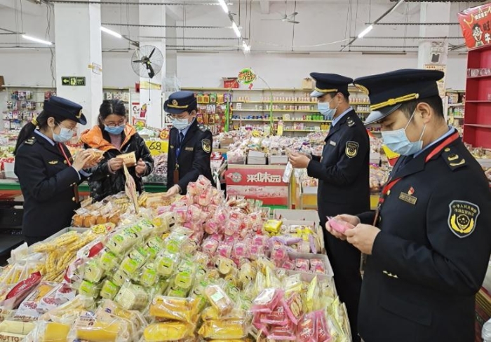 2月8日，该局执法人员在一家乡镇食品店内检查食品。