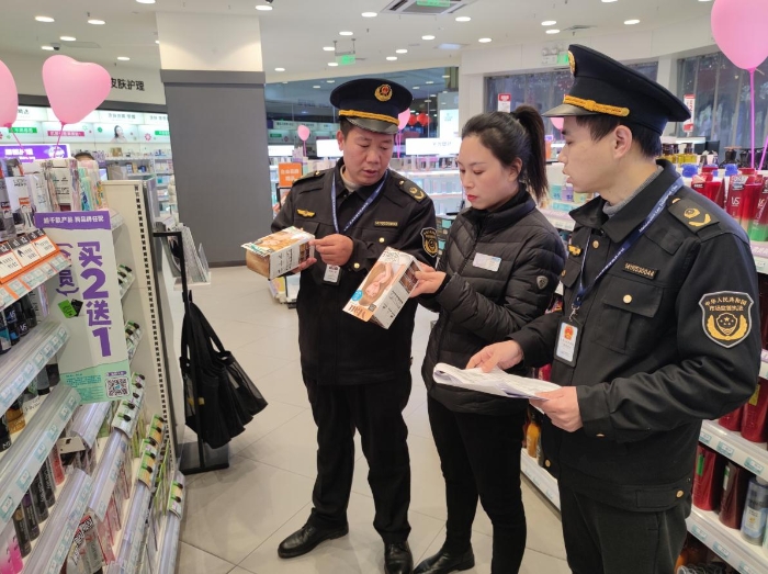 图为2月14日执法人员在化妆品专卖店检查情形。