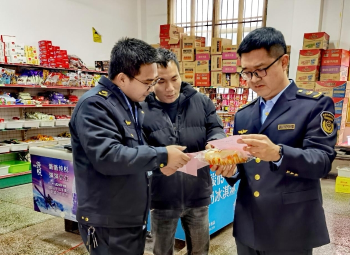 图为执法人员在新田县城东中学周边商店开展食品安全执法检查。
